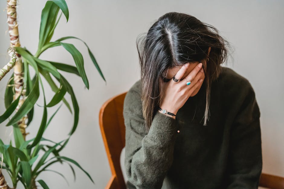 A person holding their head in their hands, depicting frustration and confusion that can be associated with Alzheimer's disease.