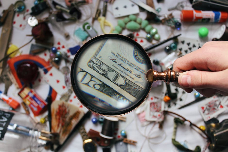 An image of a person holding a magnifying glass over a newspaper, symbolizing fact-checking in journalism.