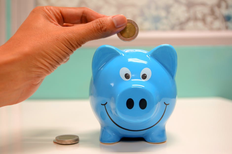 An image depicting a parent teaching their child about money by using a piggy bank and coins.