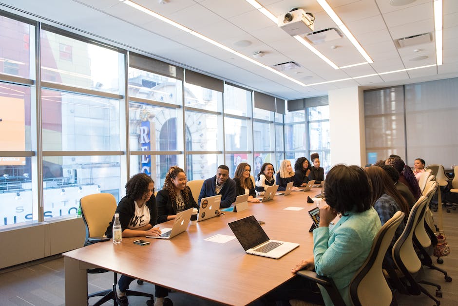 Image description: A group of diverse employees in a meeting room, exchanging ideas and working collaboratively.