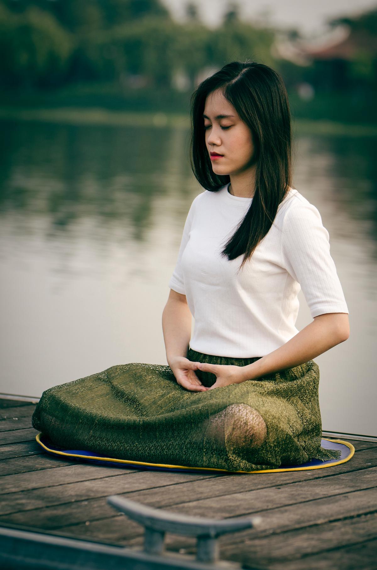 An image showing a person meditating in a peaceful environment, representing stress management.